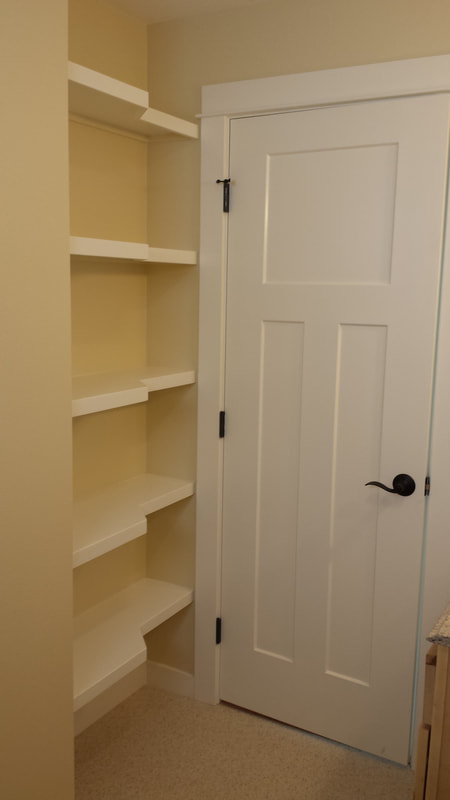 Custom shaped shelving behind a door